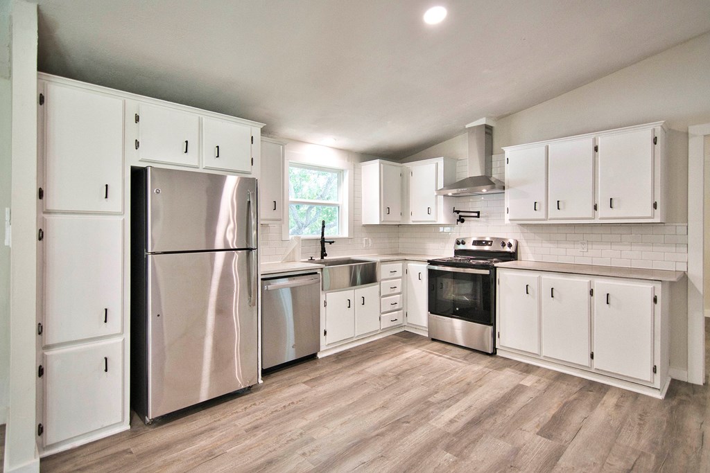 425 Post Hill Street Mason, TX 76856 - Photo 4 of 21 a kitchen with granite countertop white cabinets and white appliances