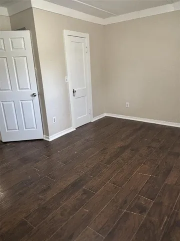 an empty room with wooden floor and sliding door