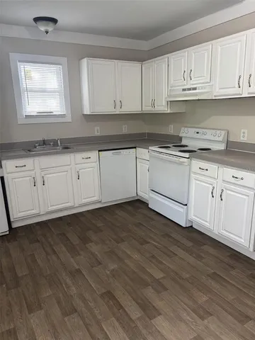 a kitchen with granite countertop wooden cabinets and white appliances