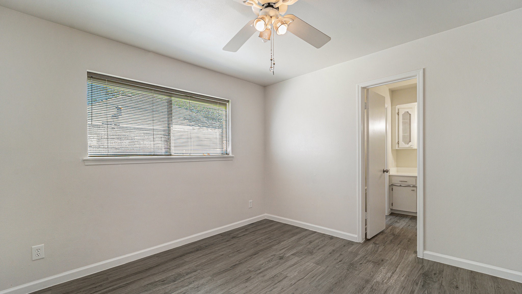 1003 Pear Tree Lane Houston, TX 77073 - Photo 12 of 15 an empty room with a chandelier fan and windows