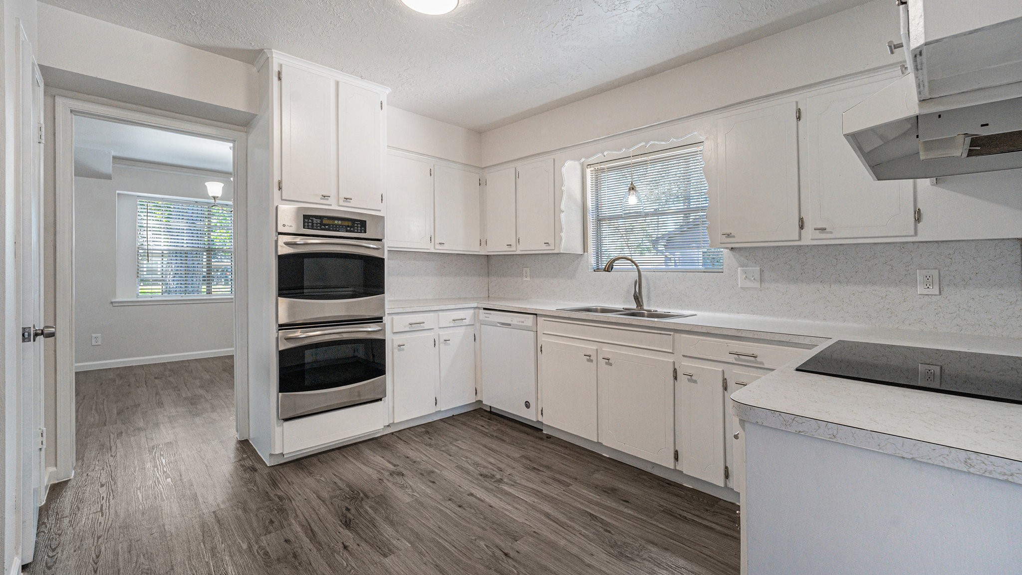 1003 Pear Tree Lane Houston, TX 77073 - Photo 6 of 15 a kitchen with cabinets stainless steel appliances a sink and wooden floor