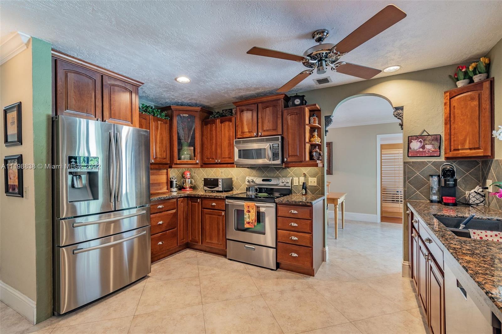 3015 Dunlin Road Delray Beach, FL 33444 - Photo 17 of 47 a kitchen with stainless steel appliances granite countertop a stove refrigerator and cabinets