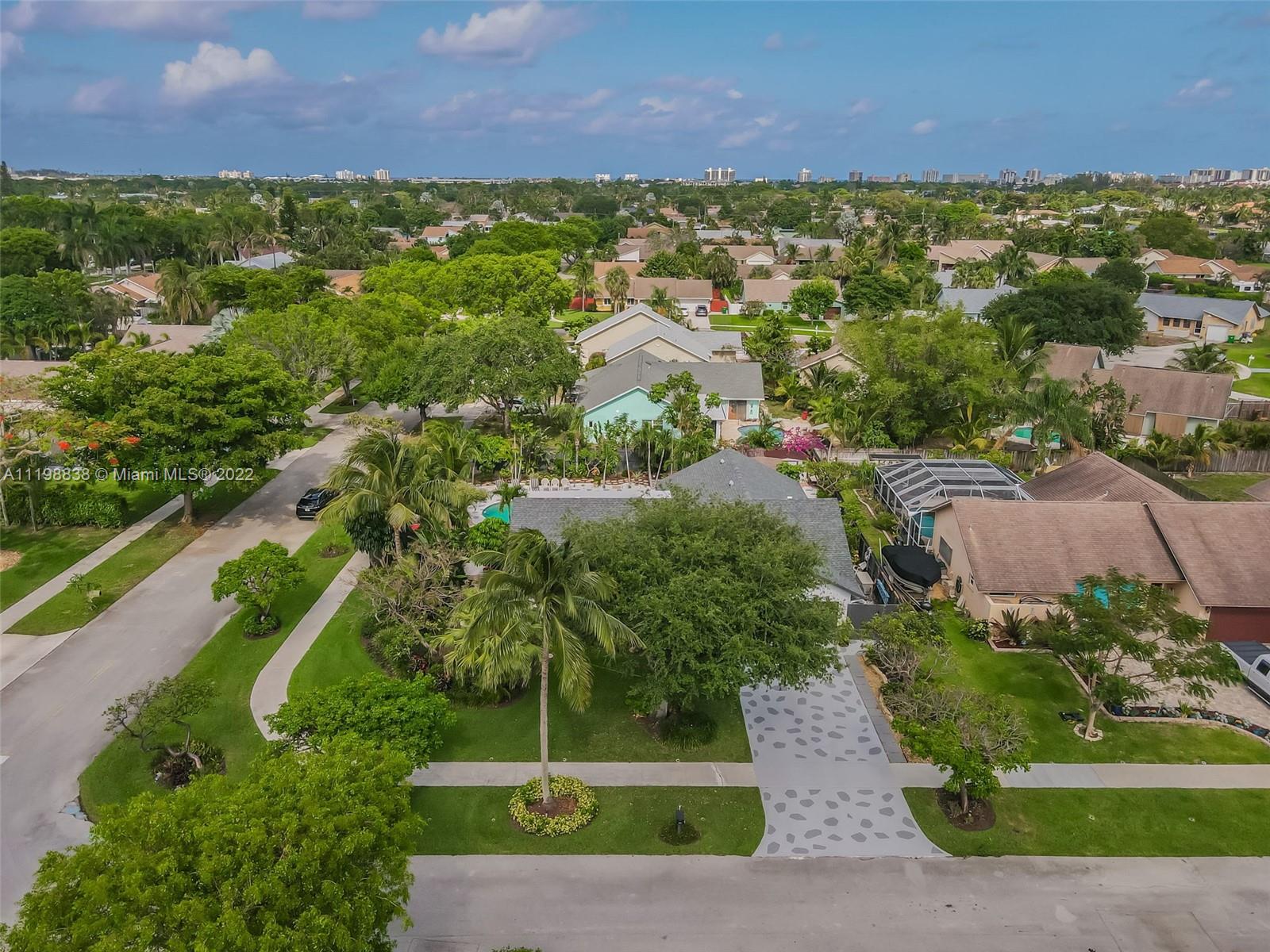 3015 Dunlin Road Delray Beach, FL 33444 - Photo 6 of 47 a view of a garden with a building in the background
