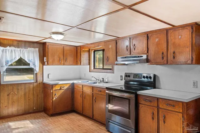 a kitchen with stainless steel appliances granite countertop a sink a stove and a refrigerator