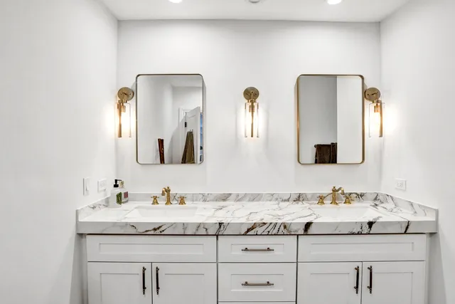 a bathroom with a granite countertop sink vanity and mirror