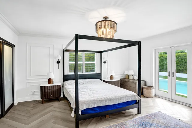 a bedroom with a bed mirror and window