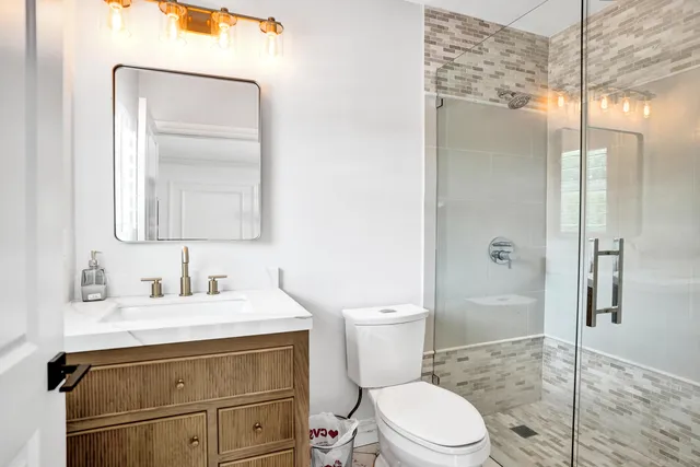 a bathroom with a sink a toilet and shower