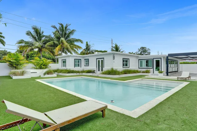 a view of a house with swimming pool and a yard
