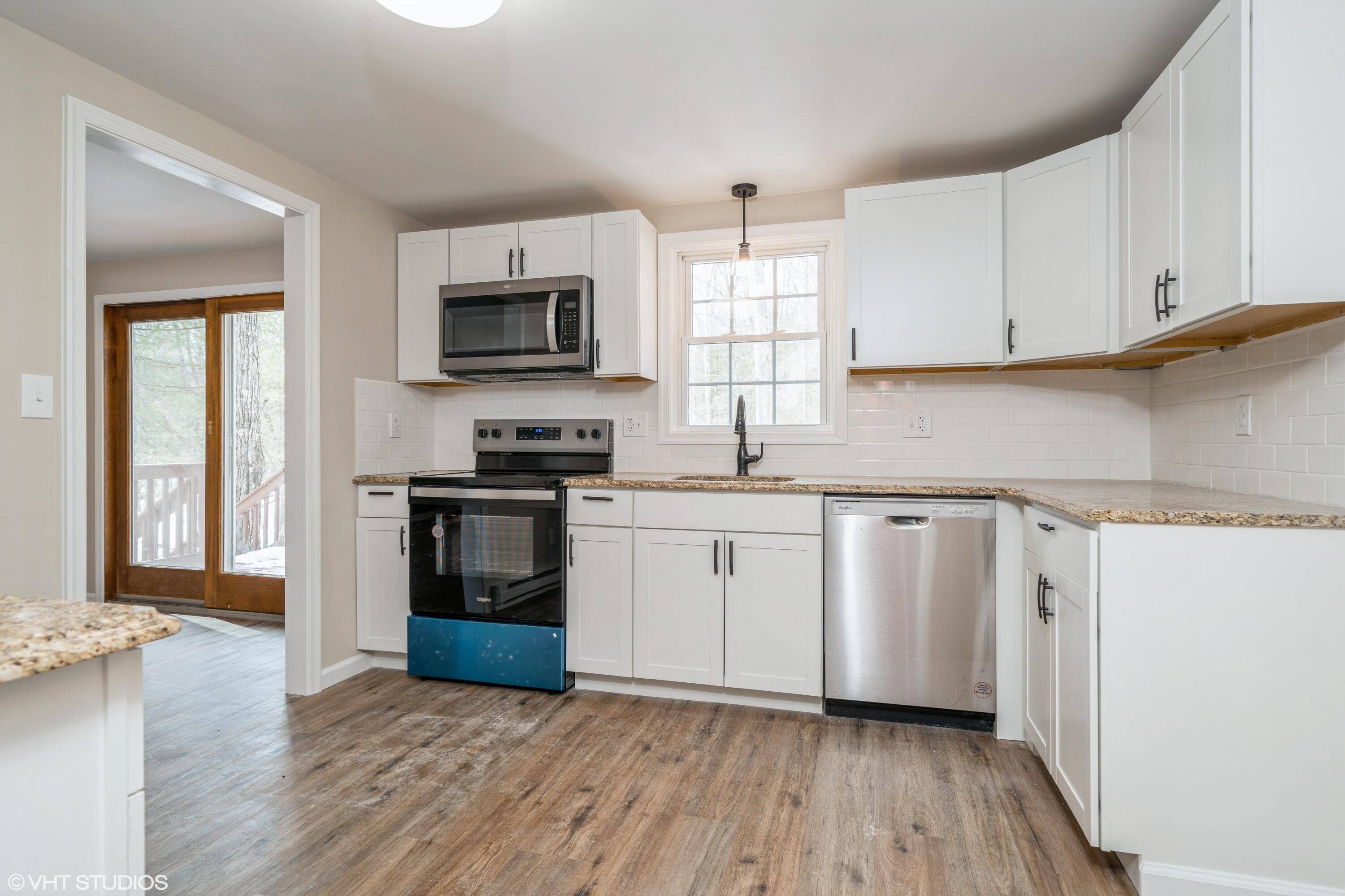 122 Fox Road Dingmans Ferry, PA 18328 - Photo 6 of 15 a kitchen with granite countertop a refrigerator and a stove top oven