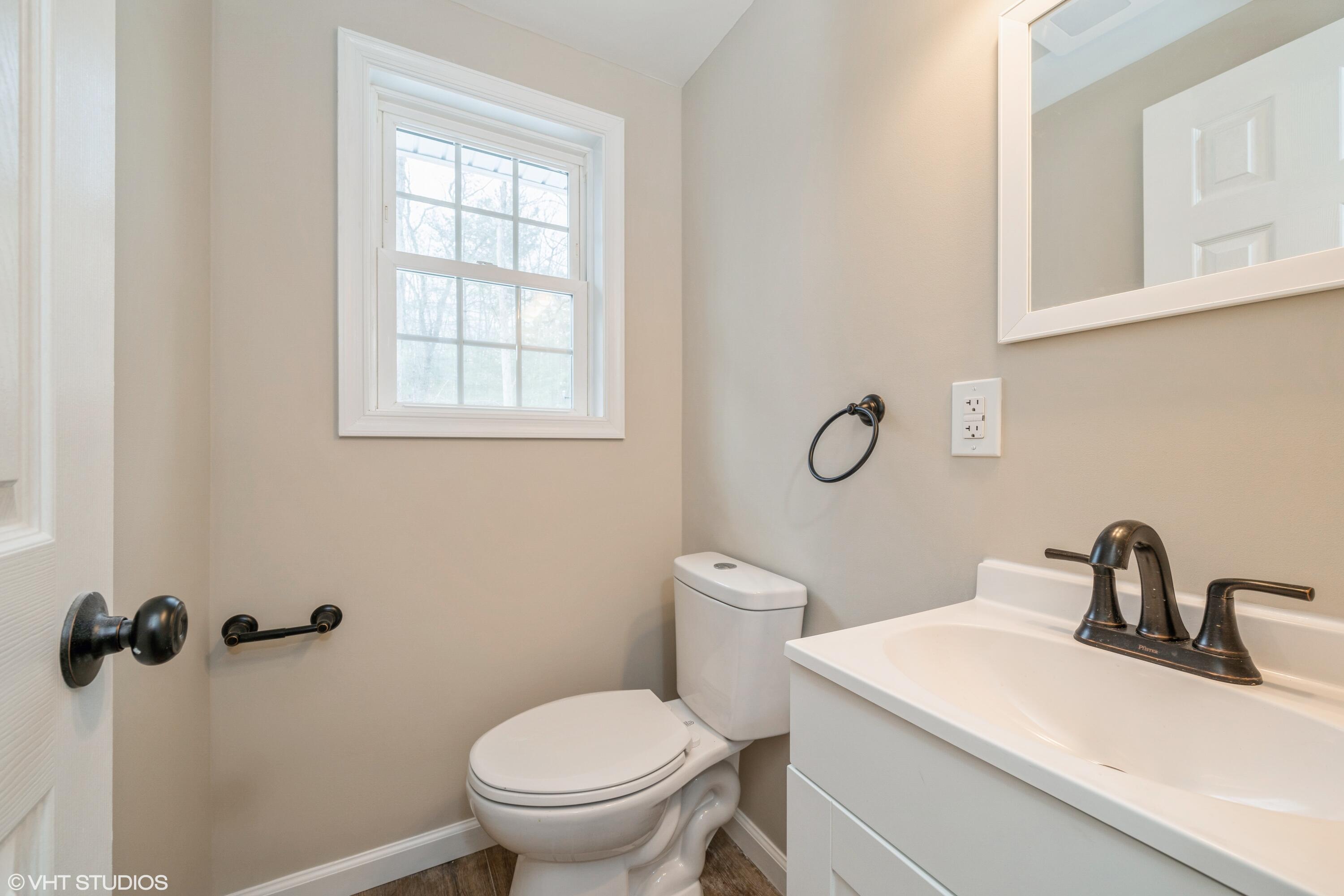 122 Fox Road Dingmans Ferry, PA 18328 - Photo 8 of 15 a bathroom with a toilet sink vanity and mirror