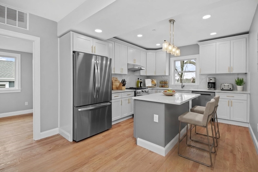 66 Stanley Street, Unit 2 Boston, MA 02125 - Photo 1 of 21 a kitchen with a refrigerator a sink and chairs