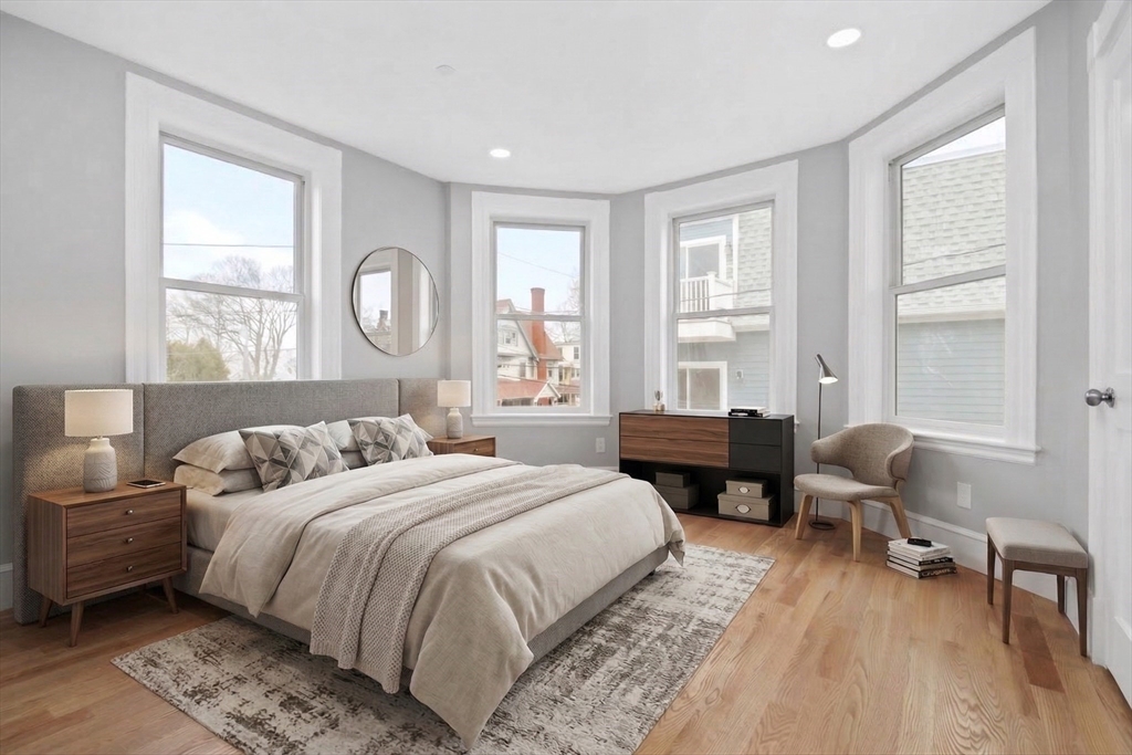 66 Stanley Street, Unit 2 Boston, MA 02125 - Photo 3 of 21 a bedroom with a bed a table and a dresser next to a window