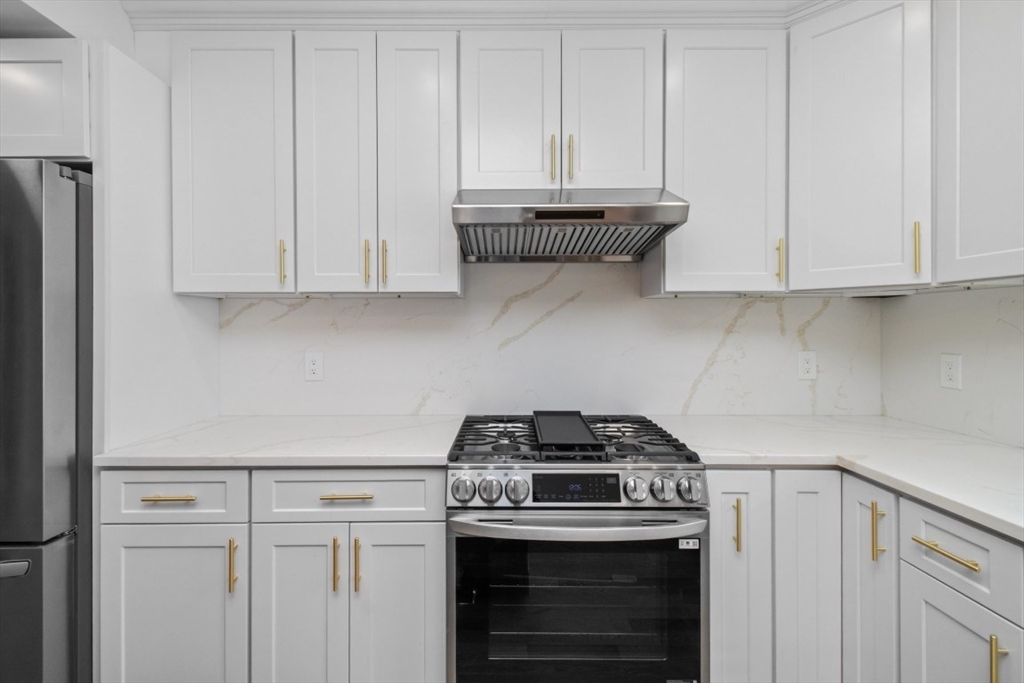 66 Stanley Street, Unit 2 Boston, MA 02125 - Photo 5 of 21 a kitchen with stainless steel appliances granite countertop white cabinets and a stove