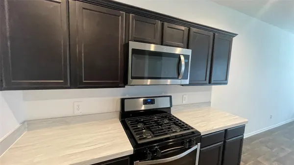 a kitchen with wooden cabinets and a stove top oven