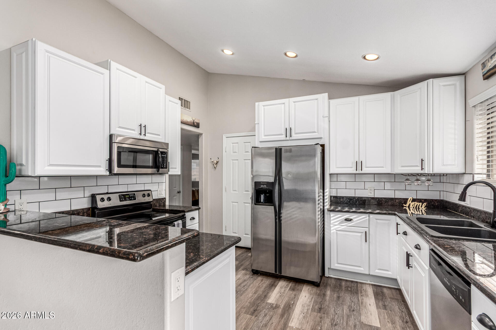567 West Spur Avenue Gilbert, AZ 85233 - Photo 3 of 42 a kitchen with stainless steel appliances granite countertop a refrigerator a stove a sink and white cabinets