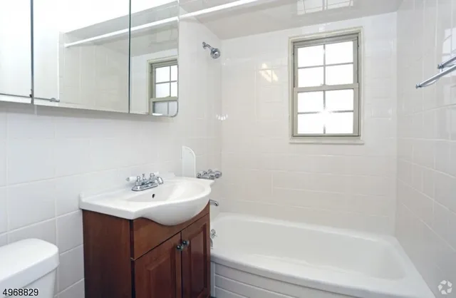 a bathroom with a sink mirror toilet and bathtub