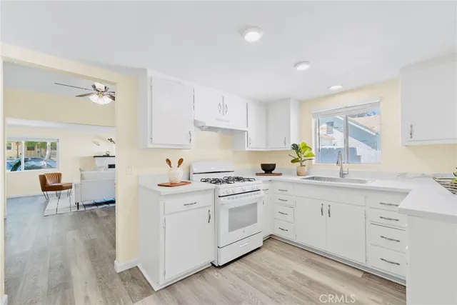 a kitchen with stainless steel appliances white cabinets and wooden floors