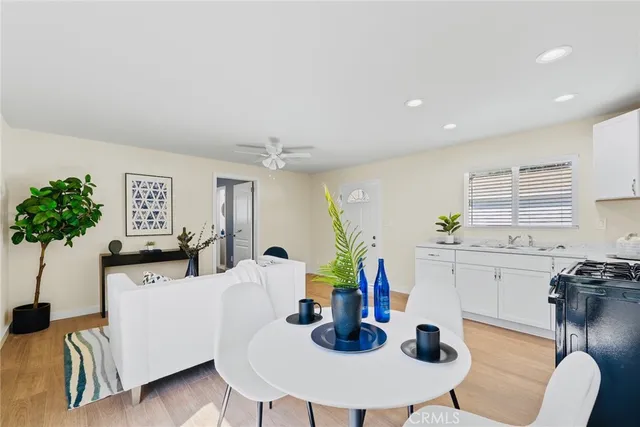 a dining room with furniture a chandelier and kitchen view