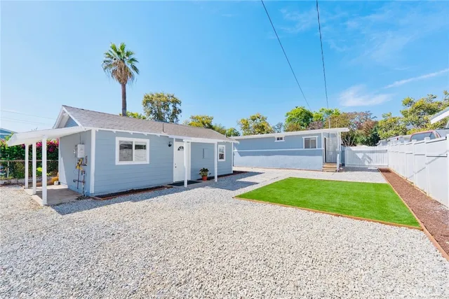 a view of a house with a yard and potted plants