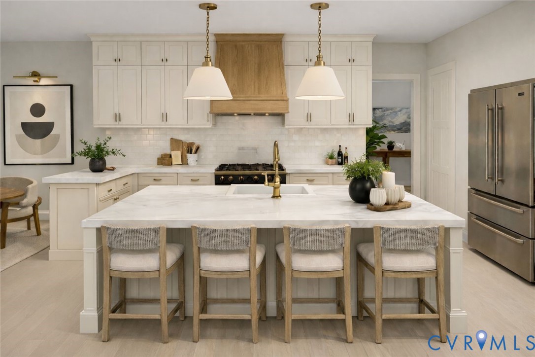 a kitchen with stainless steel appliances a white table chairs refrigerator and cabinets