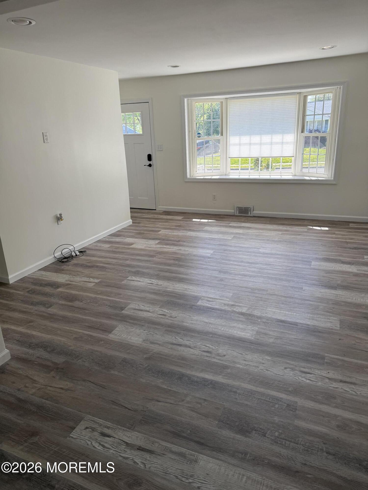 3 Lake Drive Howell, NJ 07731 - Photo 4 of 18 an empty room with wooden floor and windows