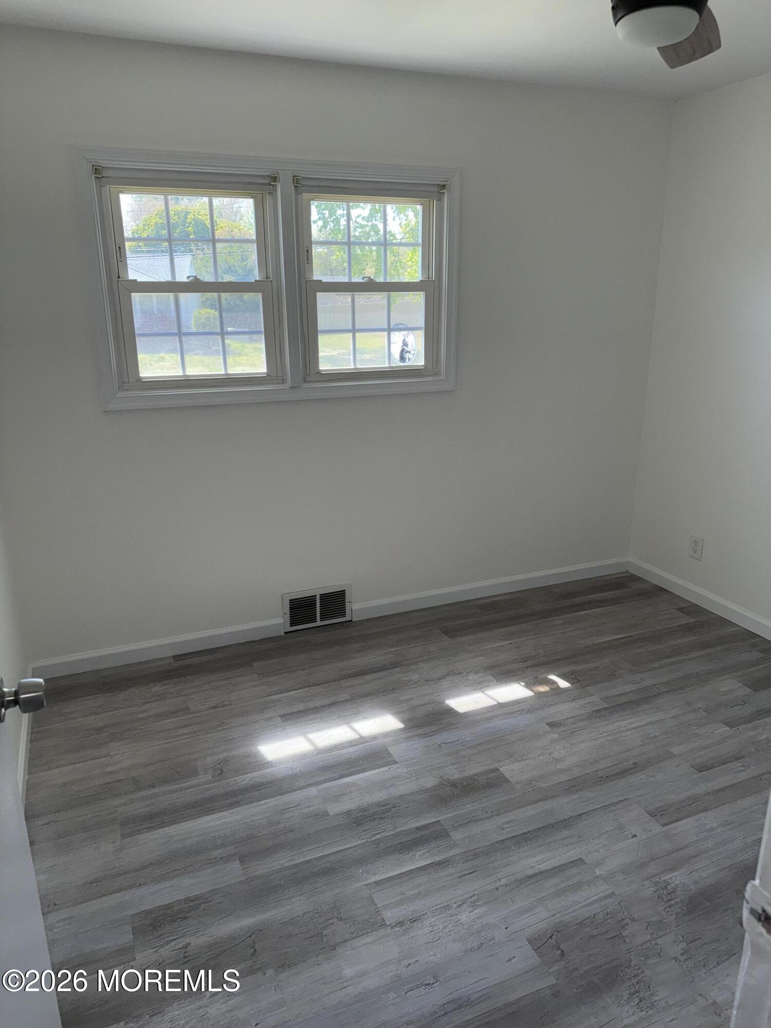 3 Lake Drive Howell, NJ 07731 - Photo 10 of 18 an empty room with wooden floor and windows