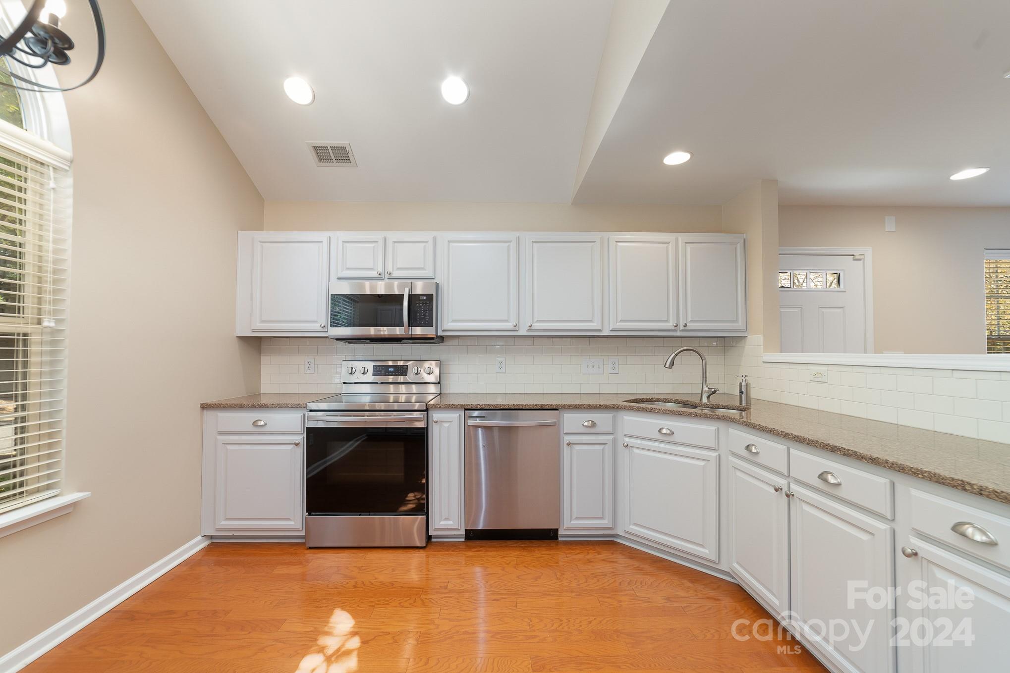 11546 Rabbit Ridge Road Charlotte, NC 28270 - Photo 6 of 17 a kitchen with stainless steel appliances granite countertop a stove a sink and a microwave