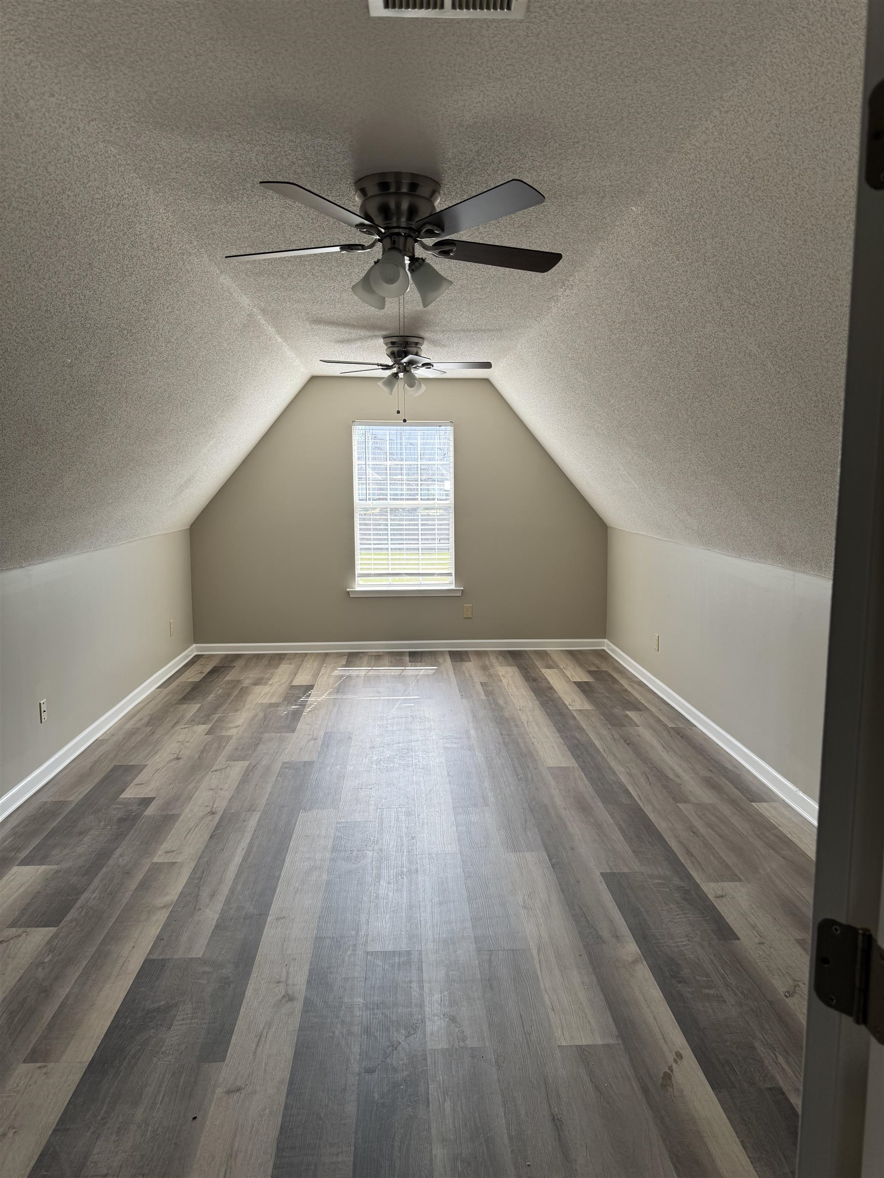 5393 Hightor Lane Memphis, TN 38125 - Photo 7 of 28 an empty room with wooden floor chandelier fan and windows