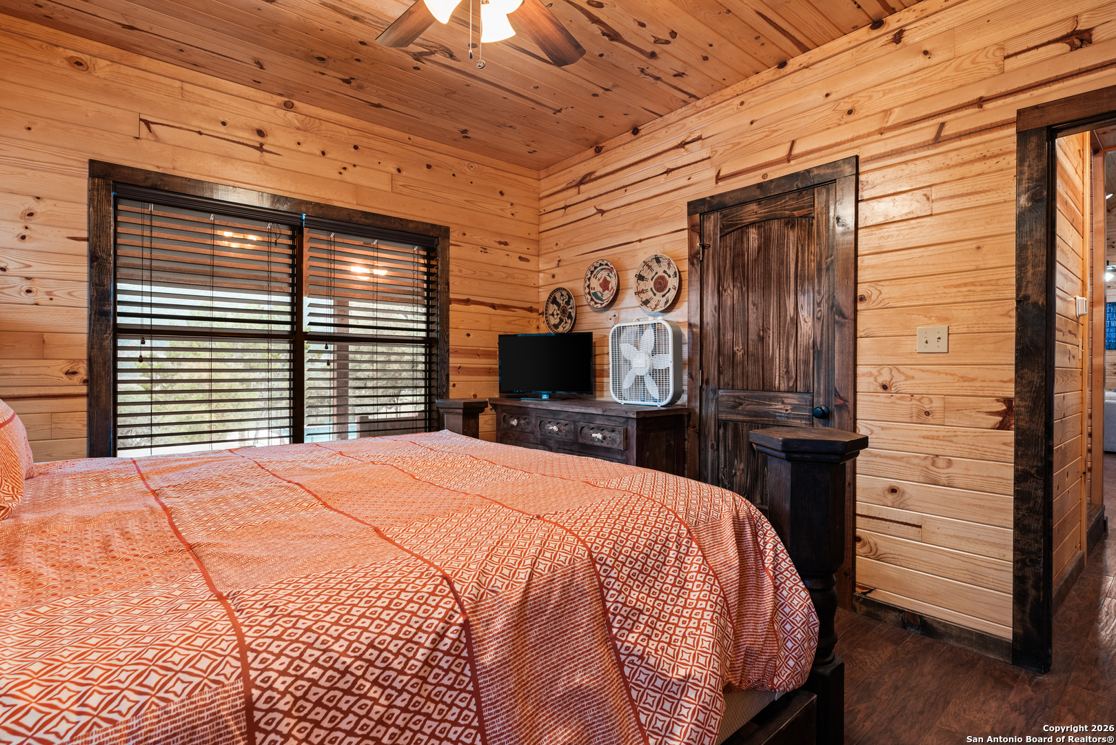 1539 River Road Concan, TX 78838 - Photo 22 of 45 a large bed sitting in a bedroom next to a window and a television