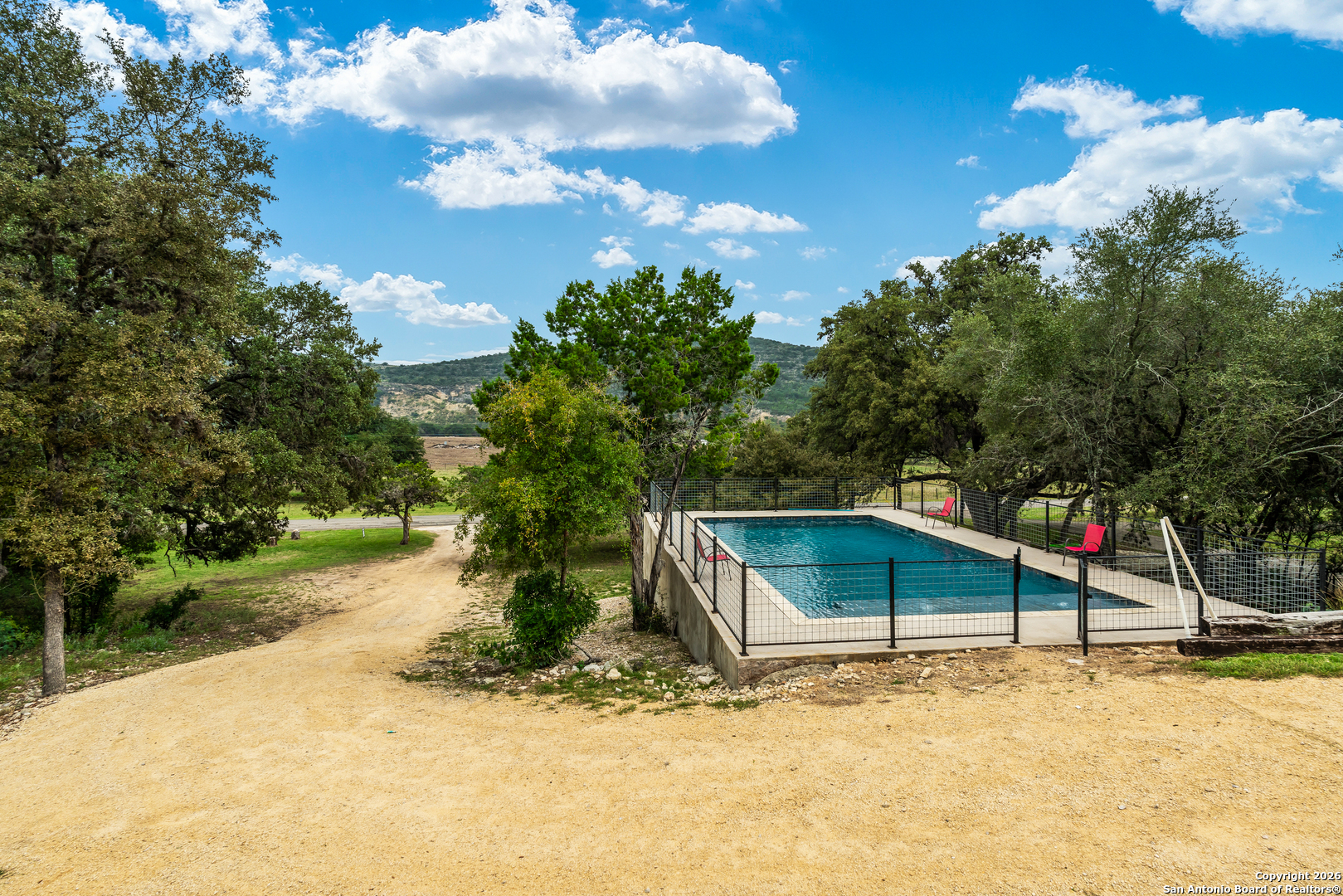 1539 River Road Concan, TX 78838 - Photo 39 of 45 a view of a barn house with a big yard and large trees