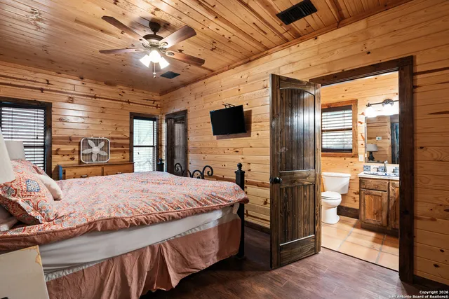 a spacious bedroom with a bed and a flat screen tv