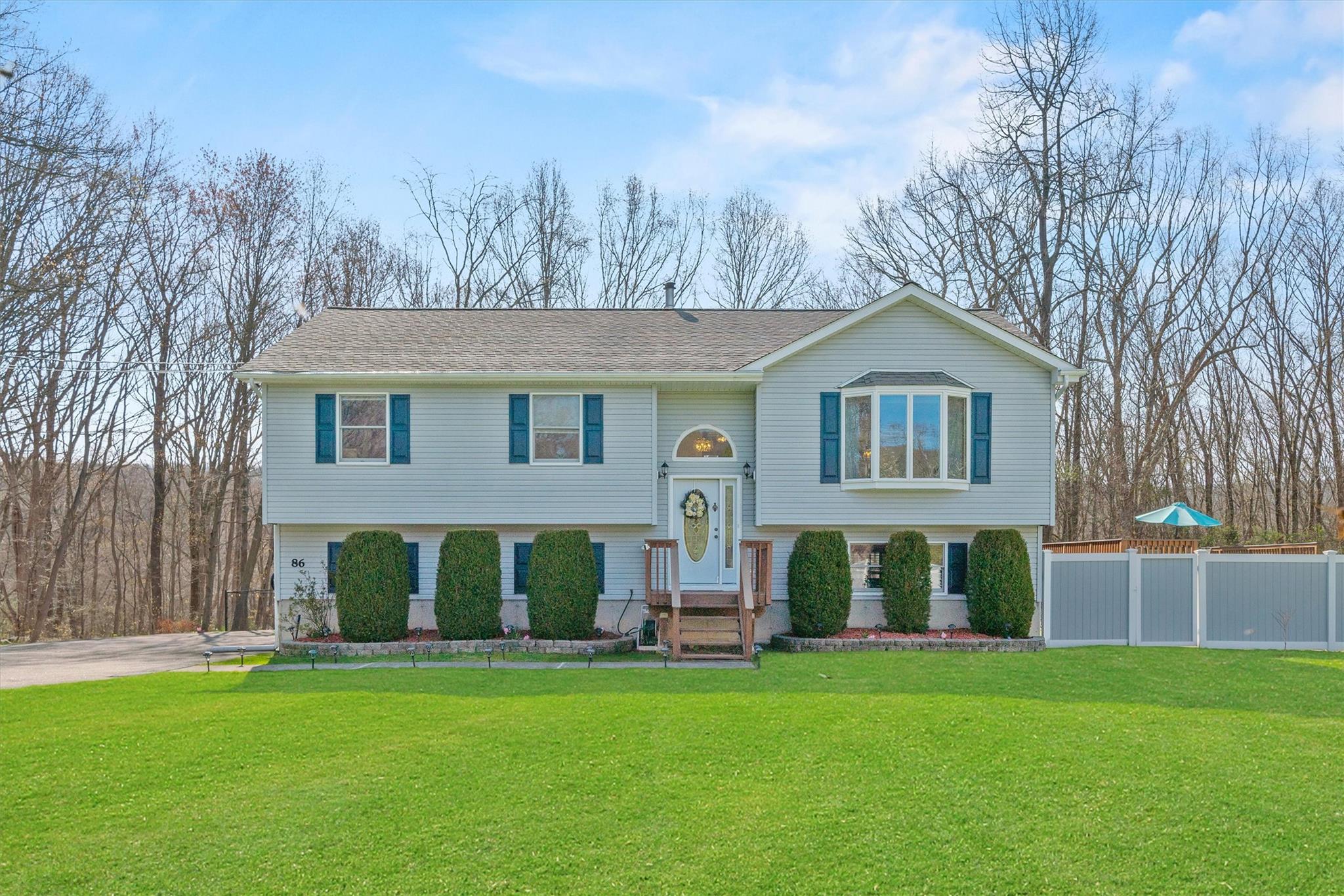 Bi-level home with a front yard and fence