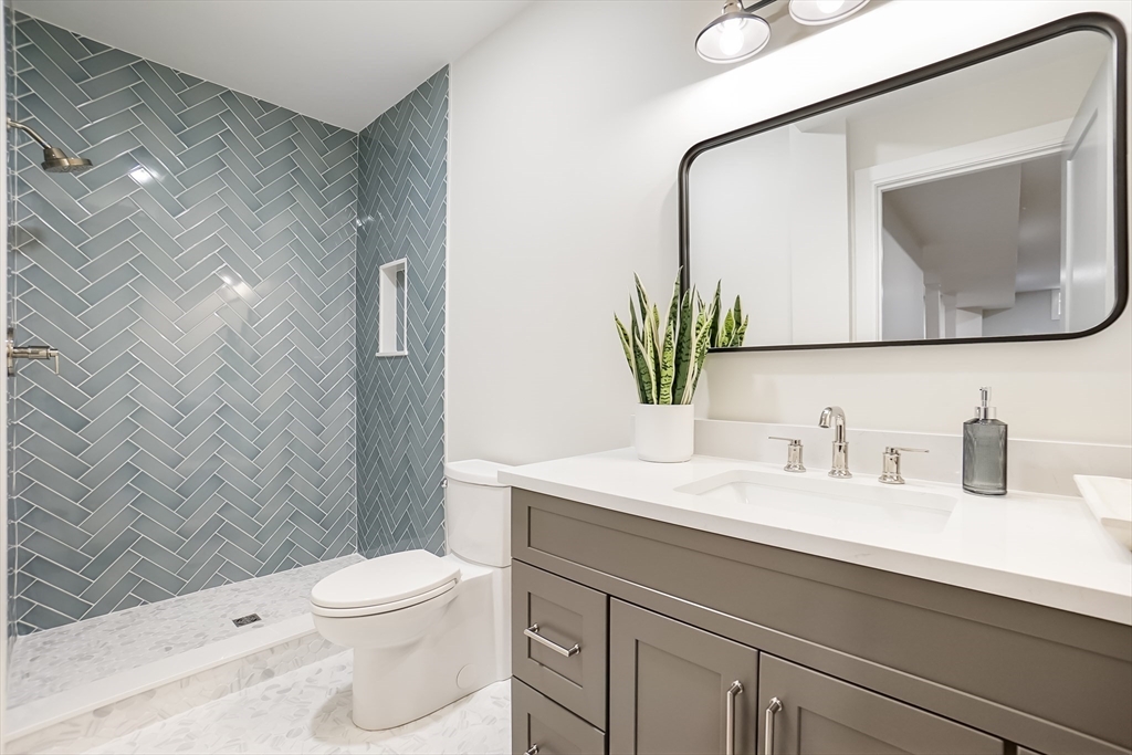 407 High Rock Street Needham, MA 02492 - Photo 33 of 36 a bathroom with a toilet a sink a faucet a shower and a mirror