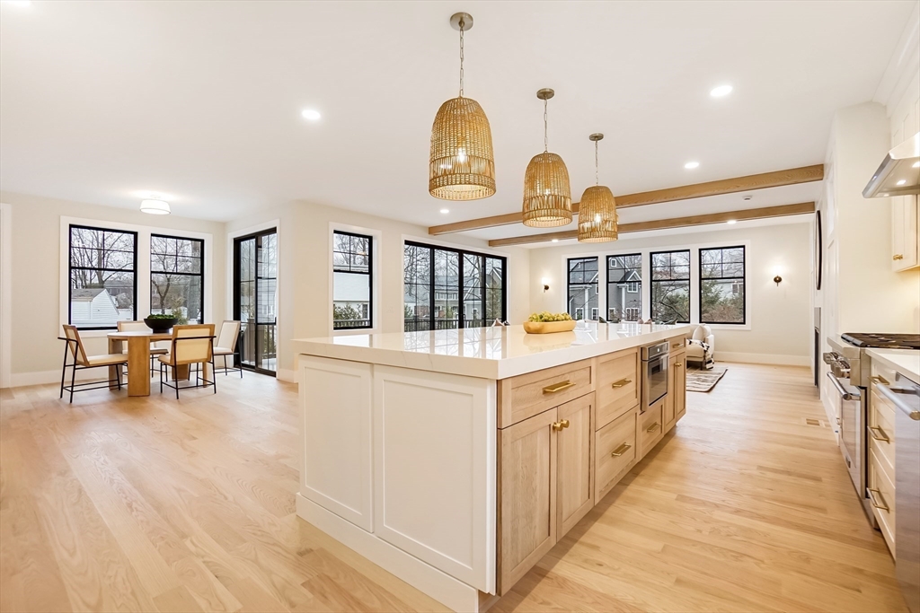 407 High Rock Street Needham, MA 02492 - Photo 8 of 36 a large white kitchen with wooden floor and a dining table