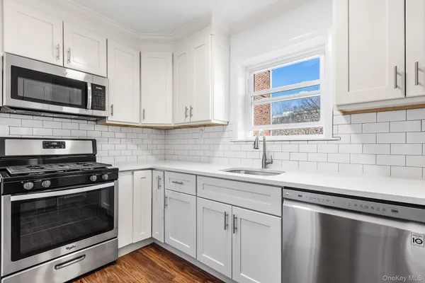 a kitchen with white cabinets and stainless steel appliances