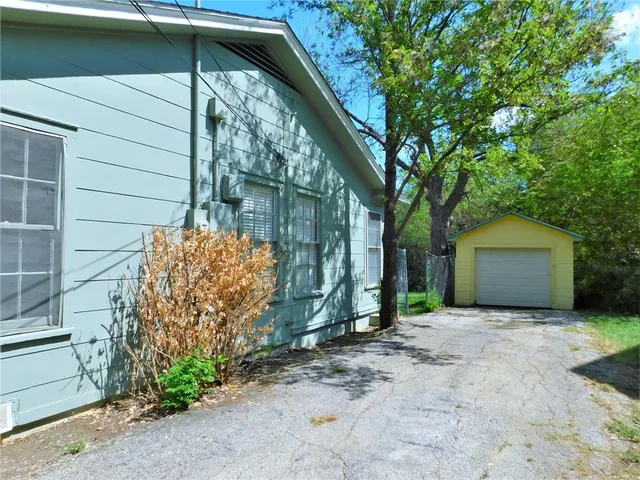 a yellow house with trees in front of it