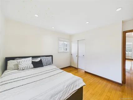 a bedroom with a bed and wooden floor