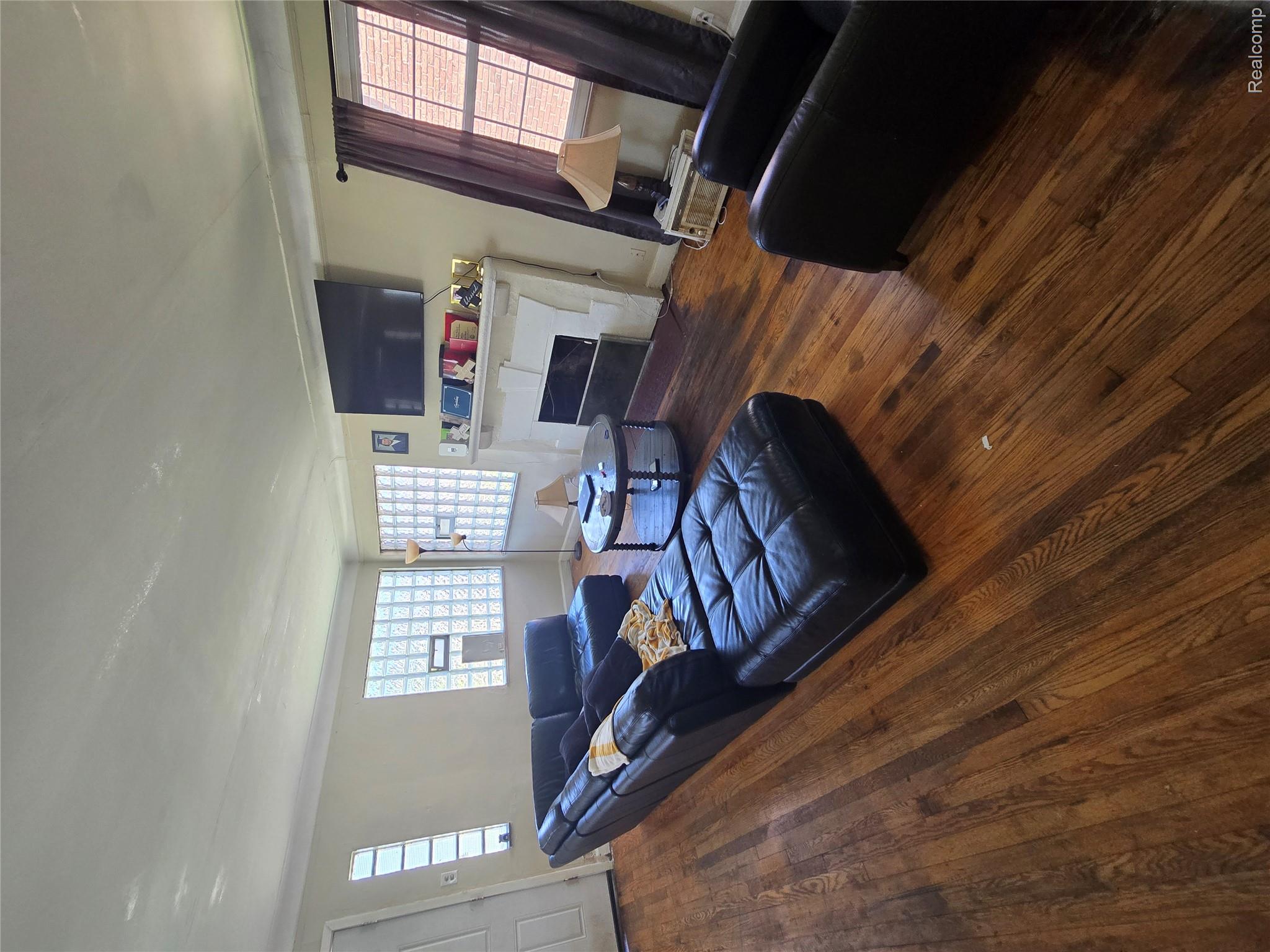 10342 Roxbury Street Detroit, MI 48224 - Photo 12 of 30 Hardwood flooring throughout, featuring a fireplace with a white mantel, and glass block windows