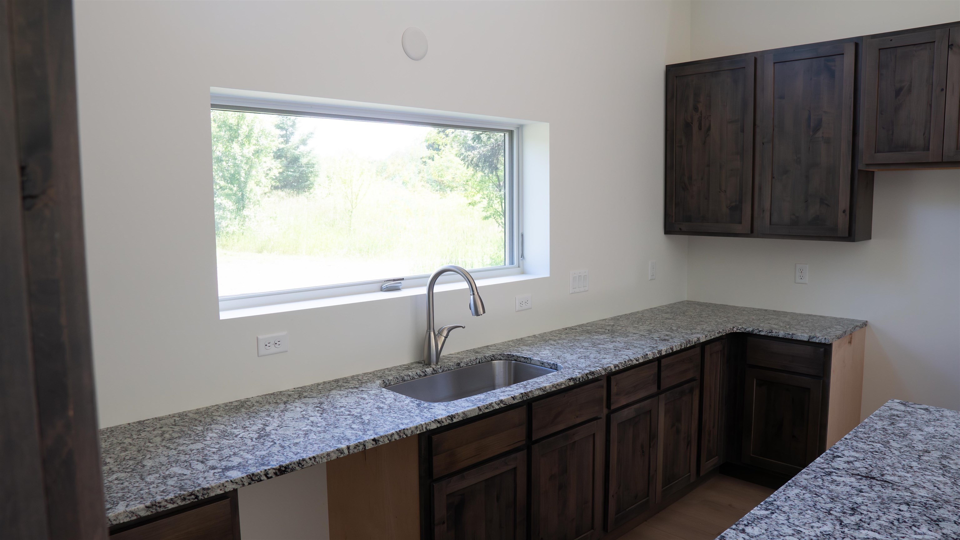 23190 Sawgrass Road Cornucopia, WI 54827 - Photo 12 of 23 Kitchen with light stone countertops, a wealth of natural light, and sink