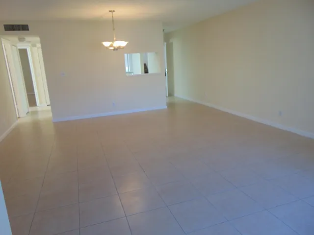 a view of a room with wooden floor and chandelier