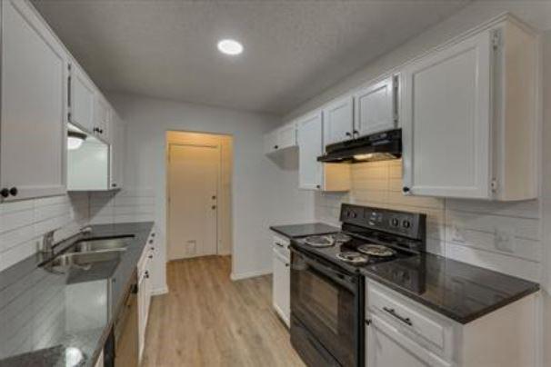 1817 San Rafael Street, Unit 1 Fort Worth, TX 76134 - Photo 5 of 15 a kitchen with granite countertop a sink stove and refrigerator