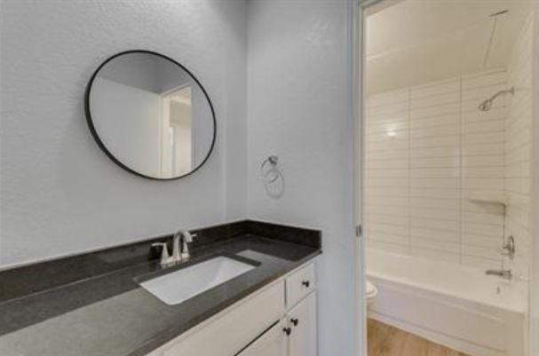 1817 San Rafael Street, Unit 1 Fort Worth, TX 76134 - Photo 7 of 15 a bathroom with a granite countertop sink and a mirror