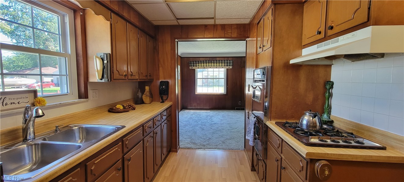33703 Guilbert Road Eastlake, OH 44095 - Photo 23 of 32 Kitchen featuring a drop ceiling, backsplash, light countertops, a healthy amount of sunlight, light hardwood floors, and stainless steel gas stovetop