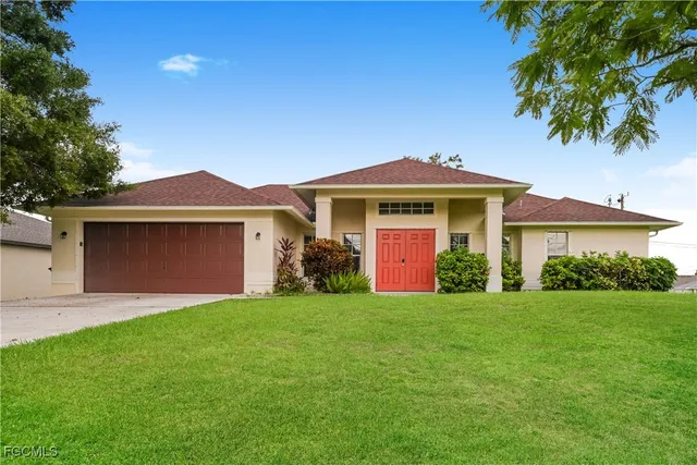 a front view of a house with a garden and yard