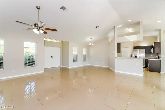 a view of an empty room and kitchen view