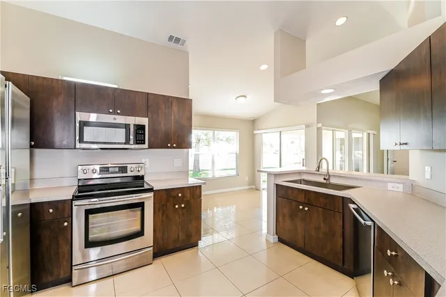 a kitchen with stainless steel appliances granite countertop a stove a sink and a microwave