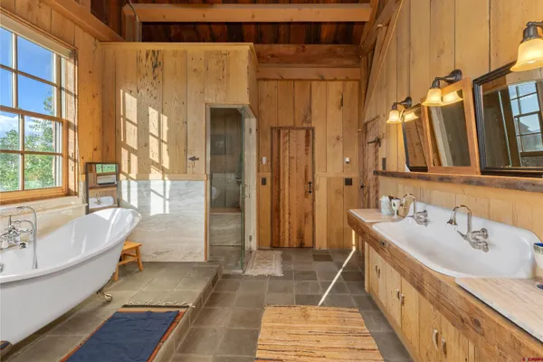 a bathroom with a tub sink and mirror