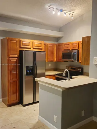 a kitchen with stainless steel appliances granite countertop a refrigerator a sink a stove and island