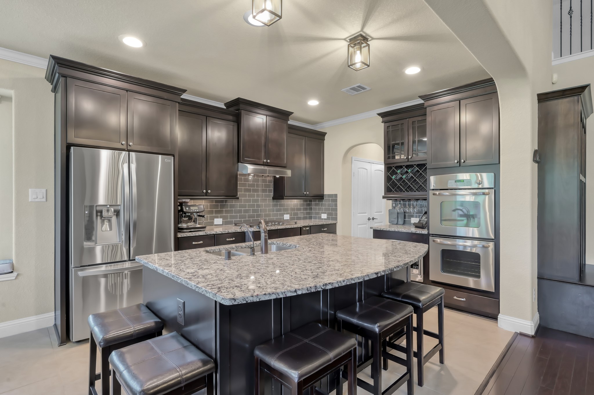 23 Rancher's Trail Tomball, TX 77375 - Photo 9 of 40 This modern kitchen dazzles with sleek cabinetry, stainless steel appliances, and updated lighting that perfectly highlights the elegant granite island, creating the ideal space for both culinary adventures and stylish entertaining.
