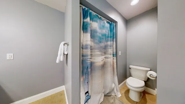 a bathroom with a granite countertop toilet and a shower